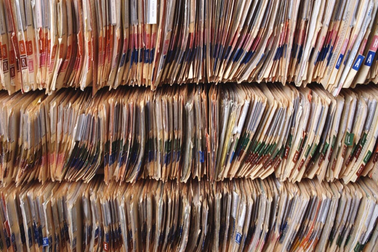 Rows of color-coded file folders organized tightly on shelves.