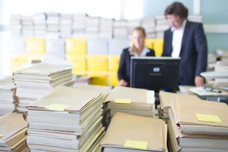 Clean paper stacks on desk in front of people