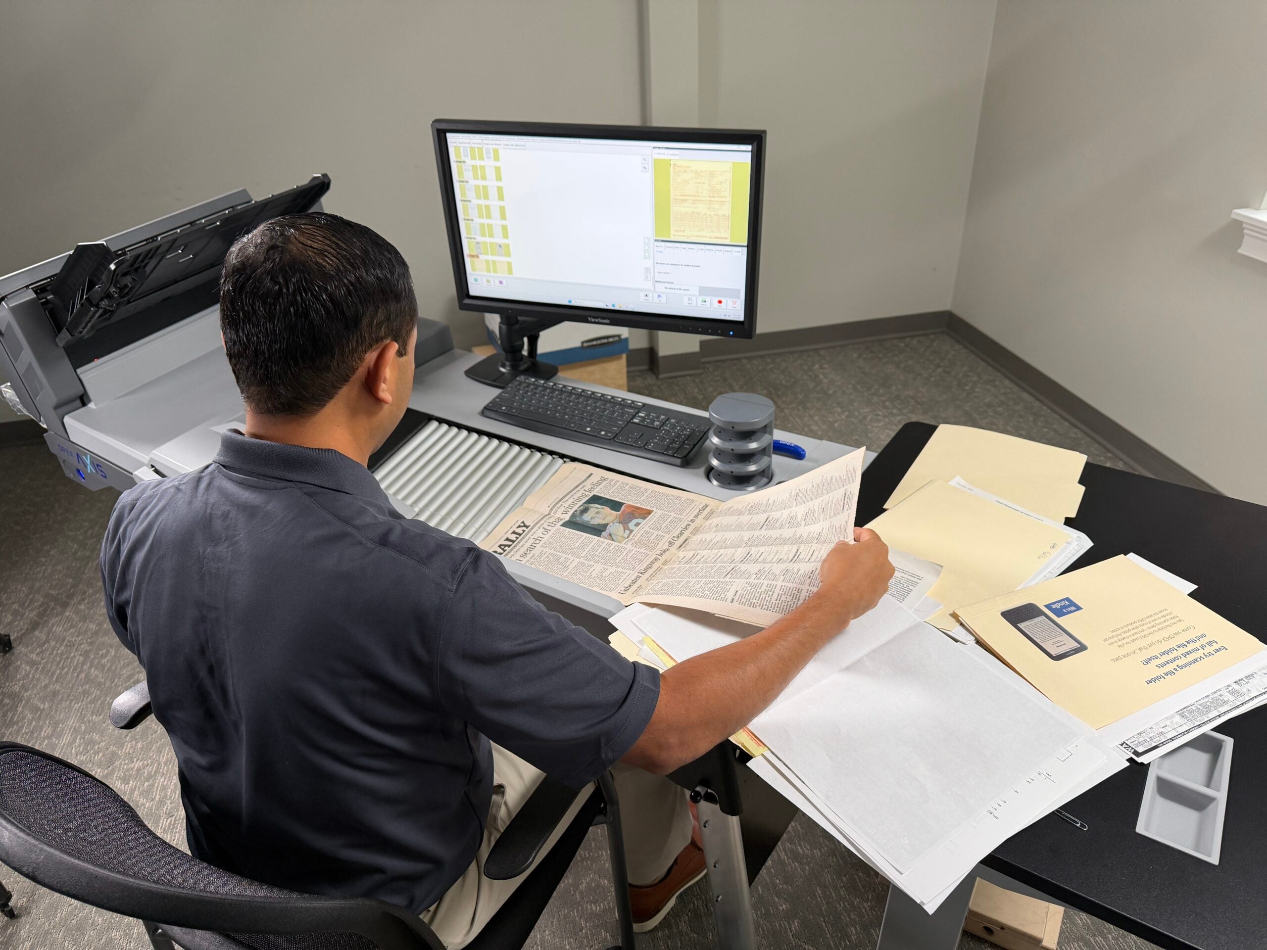 Operator feeding mixed-size documents through the OPEX Axis scanner's straight-through path